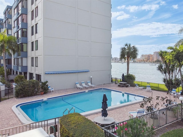 view of swimming pool with a water view and a patio