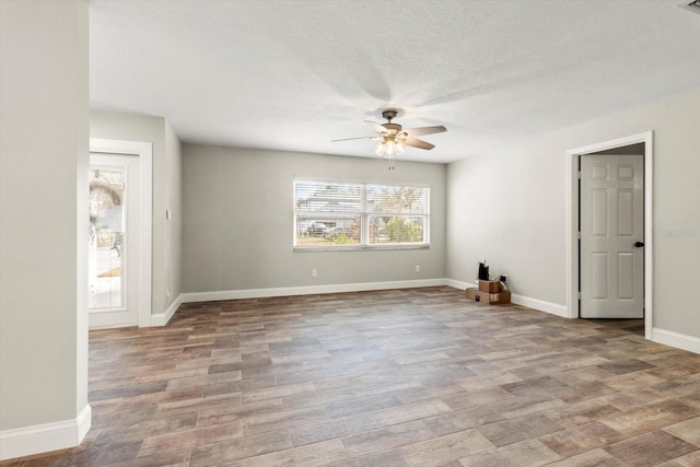 spare room featuring ceiling fan, light hardwood / wood-style flooring, and a textured ceiling