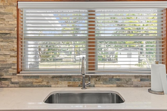 room details featuring light stone counters and sink