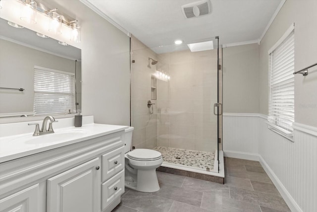 bathroom with vanity, crown molding, a shower with door, and toilet