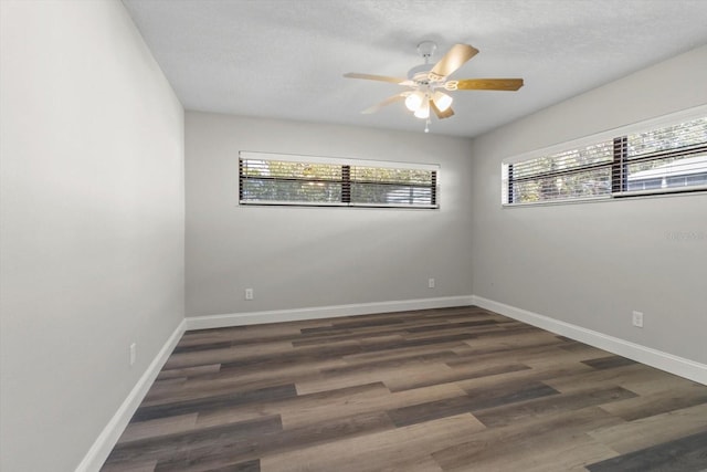 empty room featuring plenty of natural light, dark hardwood / wood-style floors, a textured ceiling, and ceiling fan