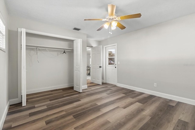 unfurnished bedroom featuring dark hardwood / wood-style flooring, a closet, and ceiling fan