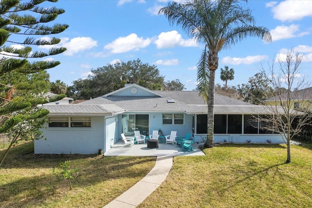 rear view of house with a sunroom, a yard, and a patio area