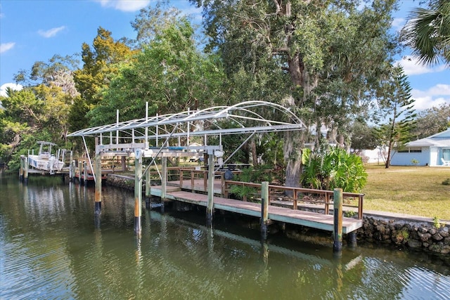 view of dock with a yard and a water view