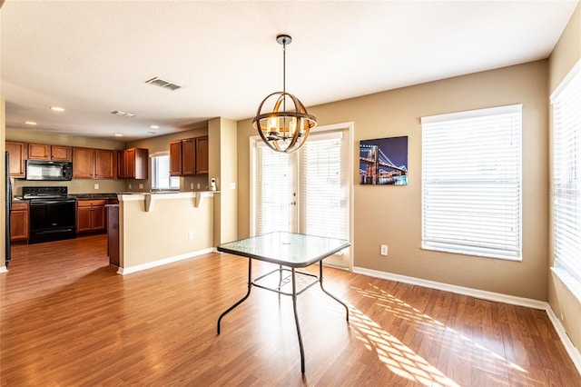 unfurnished dining area featuring wood-type flooring and a chandelier