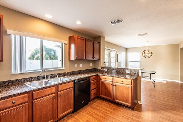 kitchen with sink, hanging light fixtures, black dishwasher, kitchen peninsula, and light wood-type flooring