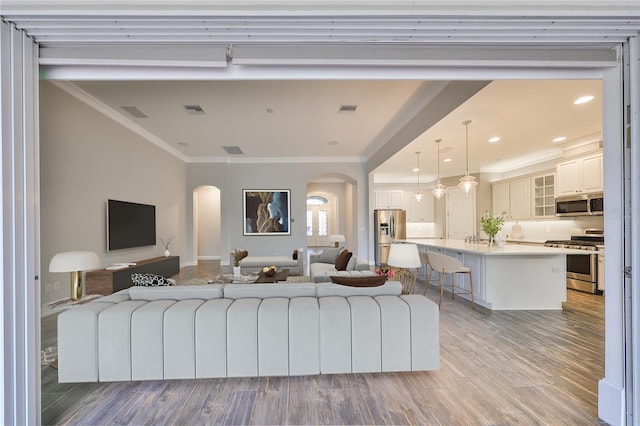 living room with crown molding and light wood-type flooring