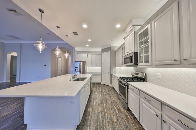 kitchen with sink, hanging light fixtures, stainless steel appliances, crown molding, and a spacious island