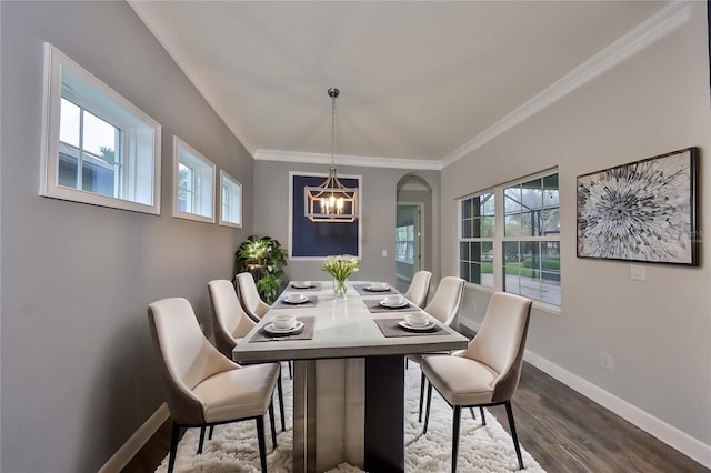 dining area featuring crown molding, dark hardwood / wood-style floors, and a chandelier