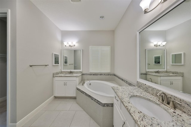 bathroom featuring vanity, a relaxing tiled tub, and tile patterned floors