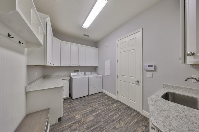 laundry room with washer and dryer, dark hardwood / wood-style floors, sink, cabinets, and a textured ceiling