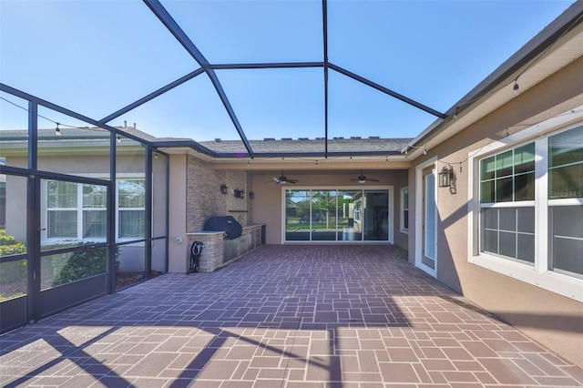 unfurnished sunroom featuring ceiling fan