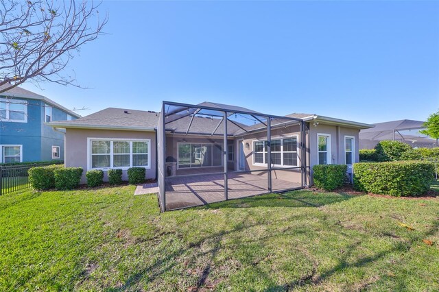 rear view of property featuring a patio, a yard, and glass enclosure