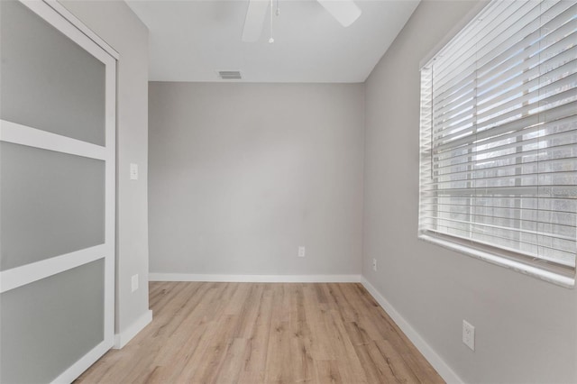 spare room with plenty of natural light, ceiling fan, and light wood-type flooring