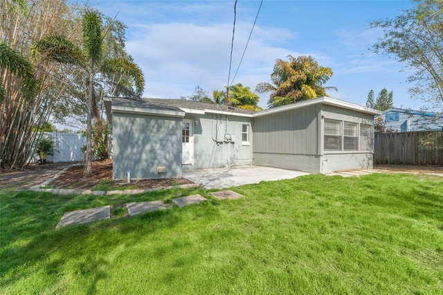 rear view of house featuring a patio and a lawn