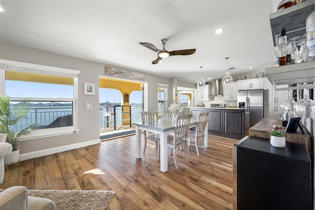 dining space featuring ceiling fan, vaulted ceiling, and light hardwood / wood-style flooring