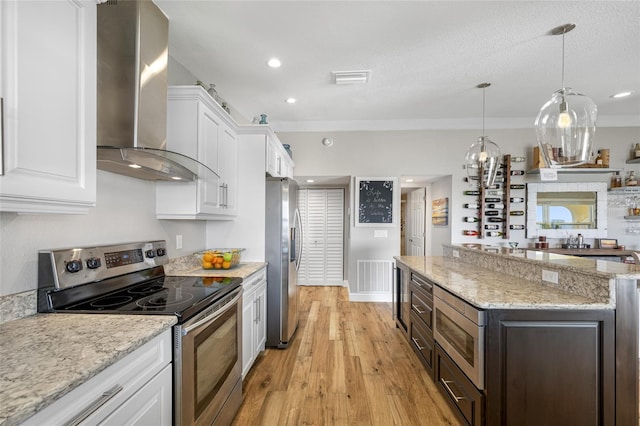 kitchen with appliances with stainless steel finishes, white cabinetry, light stone countertops, dark brown cabinets, and wall chimney exhaust hood