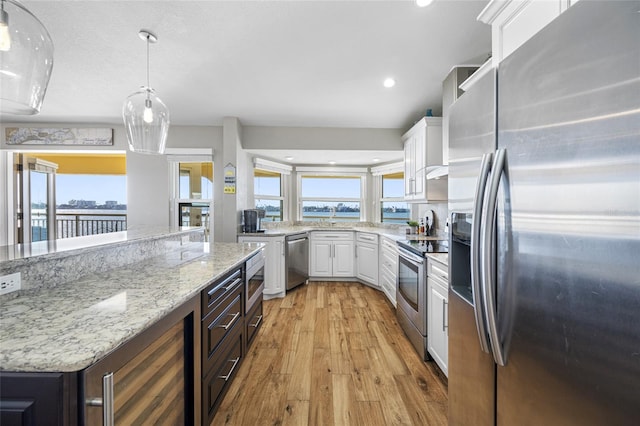 kitchen featuring wine cooler, stainless steel appliances, hanging light fixtures, and white cabinets