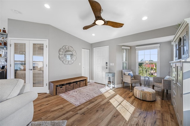 living room featuring ceiling fan, lofted ceiling, light hardwood / wood-style floors, and french doors