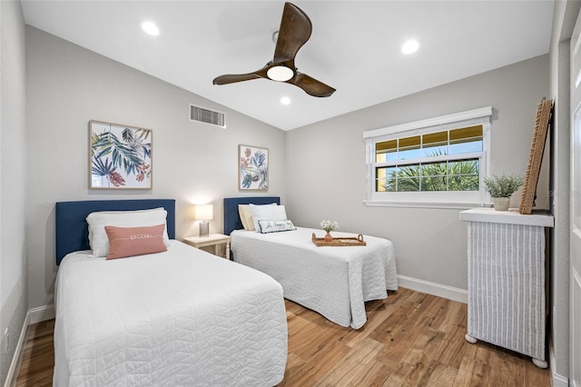 bedroom with hardwood / wood-style flooring, vaulted ceiling, and ceiling fan