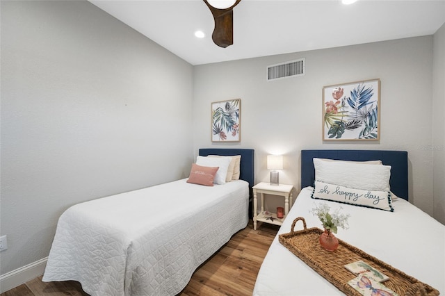 bedroom with dark hardwood / wood-style floors and ceiling fan