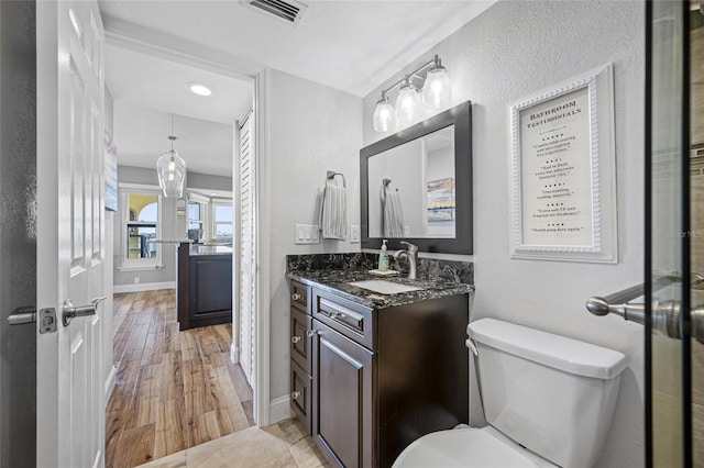 bathroom featuring wood-type flooring, vanity, and toilet