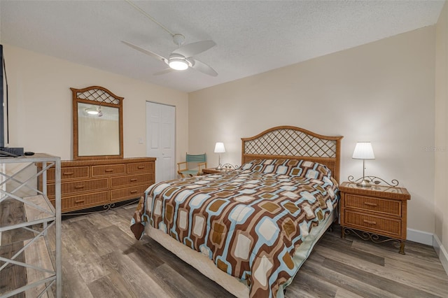 bedroom featuring ceiling fan, a textured ceiling, and dark hardwood / wood-style flooring