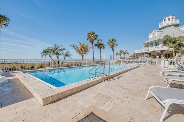 view of pool featuring a patio and a water view