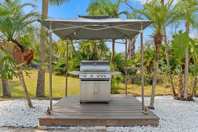 wooden terrace featuring a grill and a yard