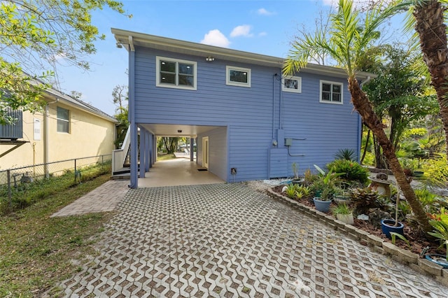 back of house with a carport and fence