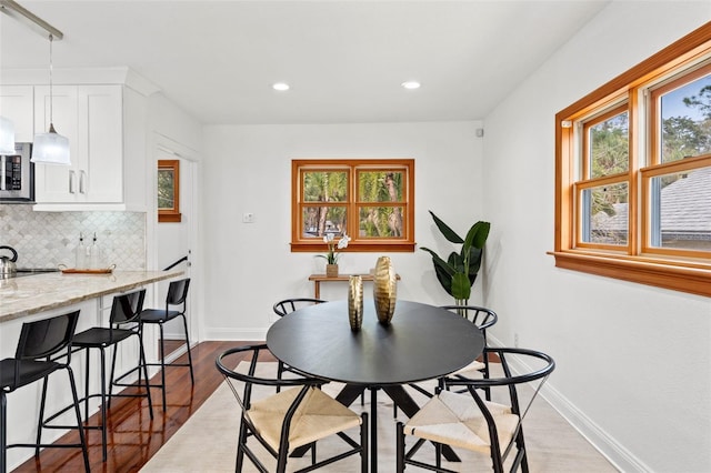 dining area with recessed lighting, dark wood finished floors, and baseboards