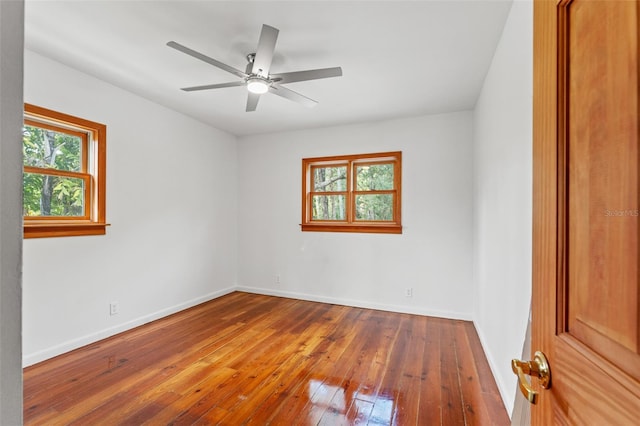 empty room featuring ceiling fan, hardwood / wood-style flooring, and baseboards