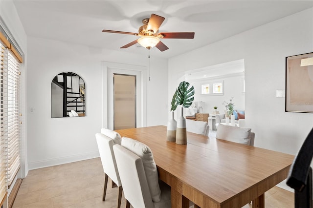 dining area with a ceiling fan and baseboards