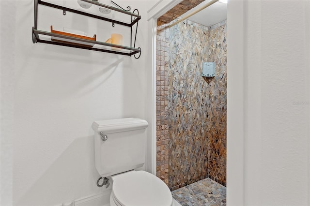 bathroom featuring toilet and a tile shower