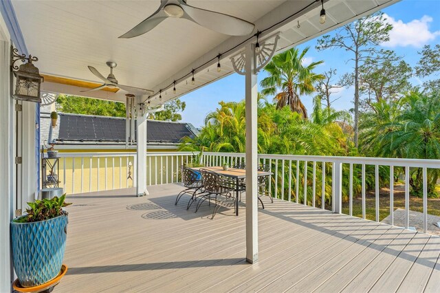 wooden deck featuring outdoor dining area and a ceiling fan