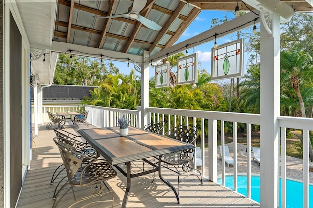 deck with outdoor dining area and an outdoor pool