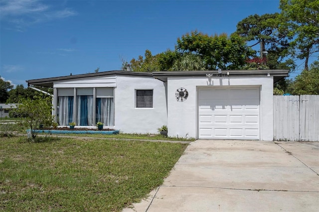 ranch-style house featuring a garage and a front lawn