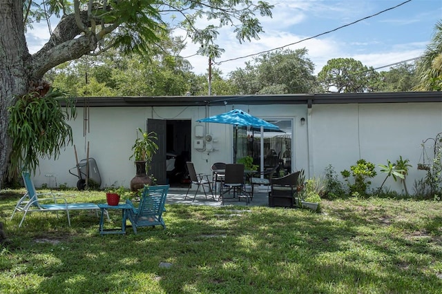 back of property featuring a lawn and a patio area