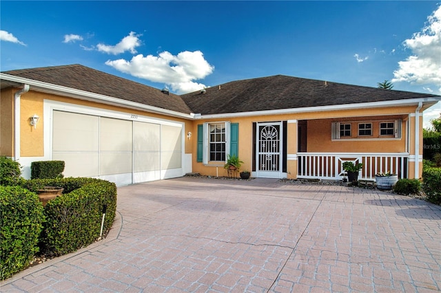 ranch-style home featuring a garage, a porch, decorative driveway, and stucco siding