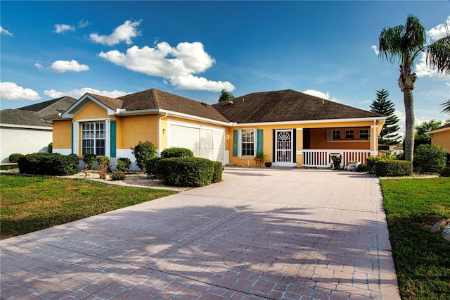 single story home with a garage, covered porch, decorative driveway, a front lawn, and stucco siding