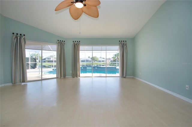 unfurnished room featuring light wood-style floors, plenty of natural light, and vaulted ceiling