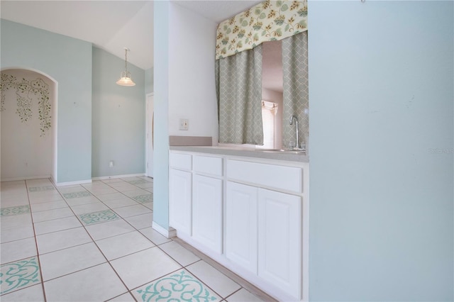 full bathroom with lofted ceiling, tile patterned flooring, baseboards, and vanity