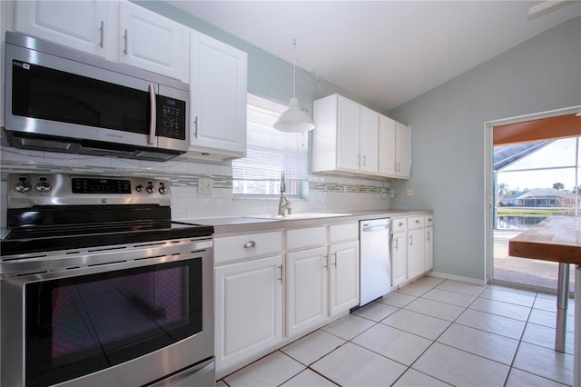 kitchen featuring stainless steel appliances, lofted ceiling, light countertops, white cabinetry, and a sink