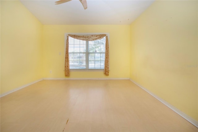 unfurnished room with a ceiling fan, baseboards, and wood finished floors