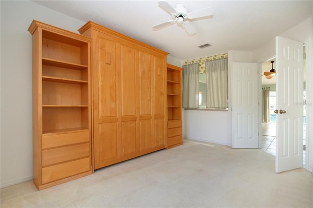 unfurnished bedroom featuring a ceiling fan, light colored carpet, and visible vents