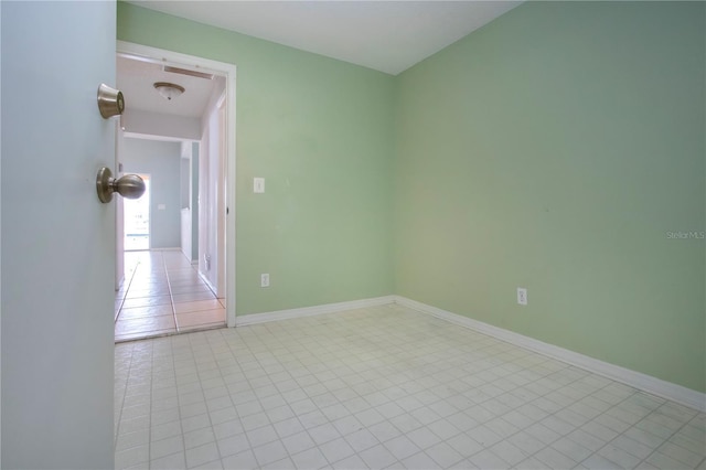 unfurnished room with light tile patterned floors and baseboards