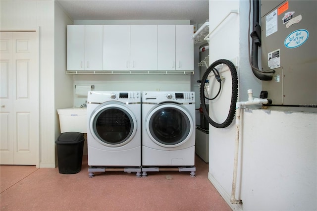 laundry area with cabinet space, a sink, and separate washer and dryer