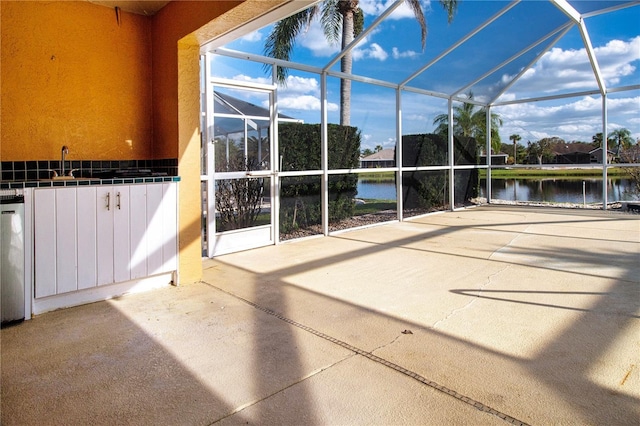 view of patio / terrace featuring a lanai and a water view