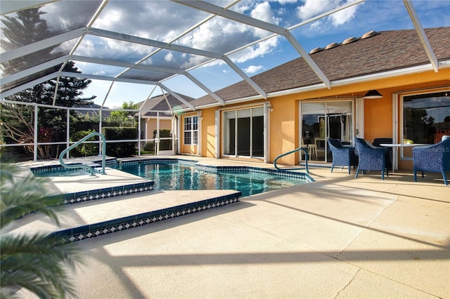 pool with glass enclosure, a patio area, and a jacuzzi