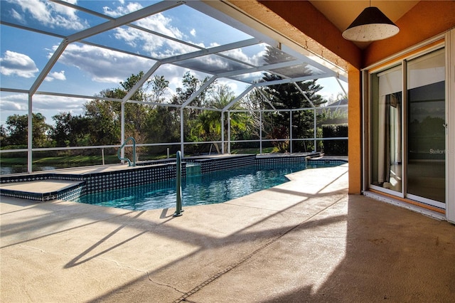 view of pool featuring glass enclosure, a pool with connected hot tub, and a patio area